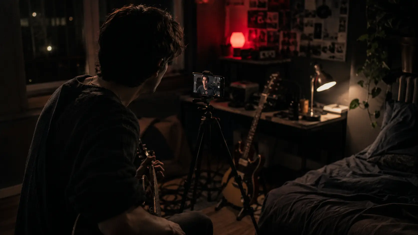 Independent musician filming a song alone in a bedroom at night
